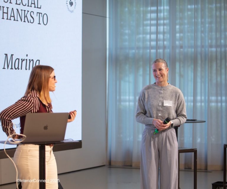 Marina Leushacke Profilbild Junge Frau mit hellblondem Haar, lächelt und trägt einen grauen Pullover und eine Kette.